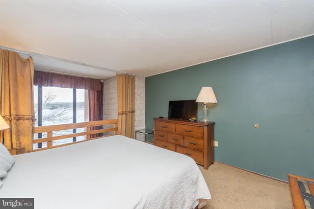 a bedroom with a bed and a lamp on dresser