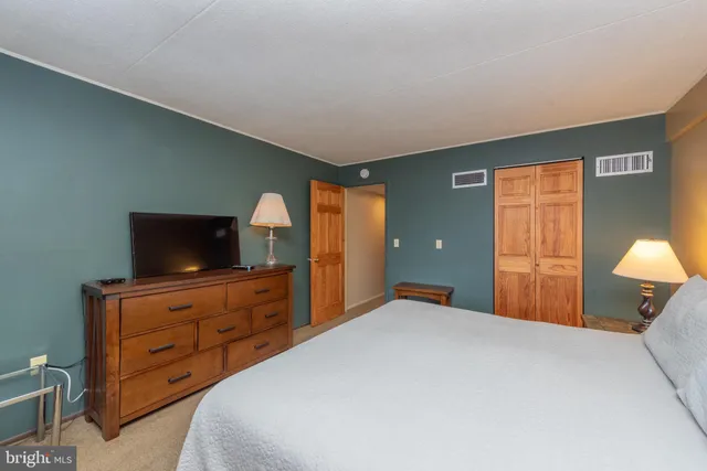 a bedroom with a bed and a large window