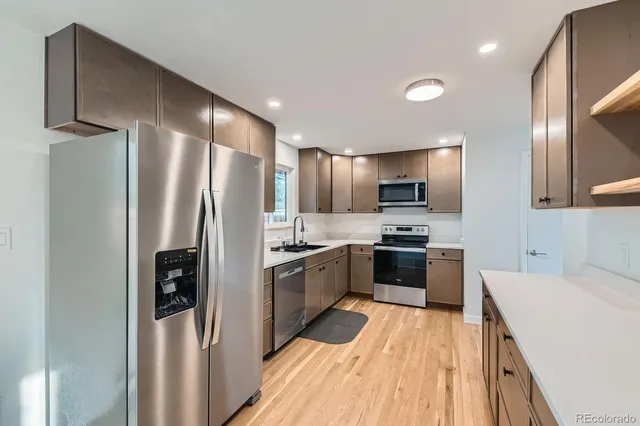 a kitchen with stainless steel appliances a refrigerator sink and microwave