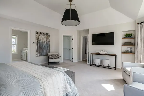 a spacious bedroom with a bed and a flat screen tv