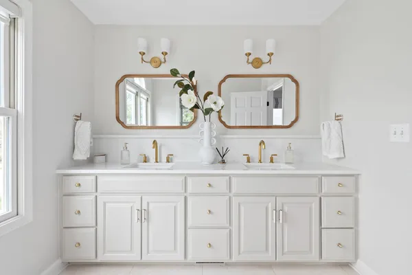 a bathroom with white cabinets and sink