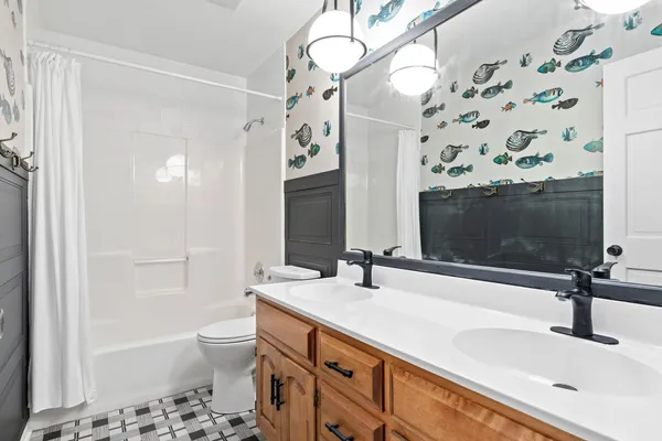 a bathroom with a sink a toilet a mirror and shower