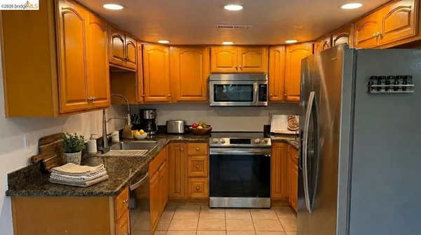 a kitchen with stainless steel appliances granite countertop a stove top oven a sink and dishwasher