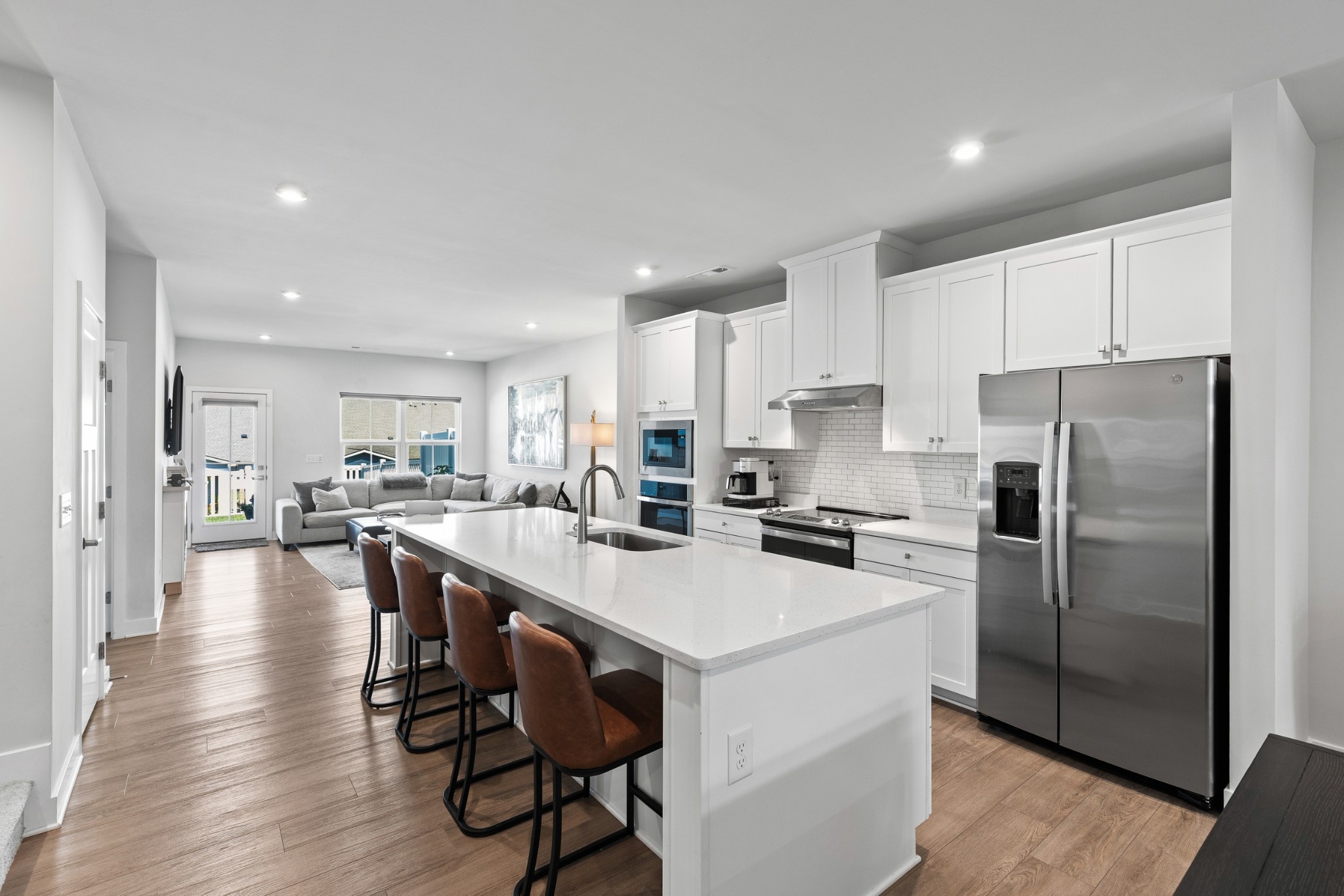 a kitchen with refrigerator a sink and chairs