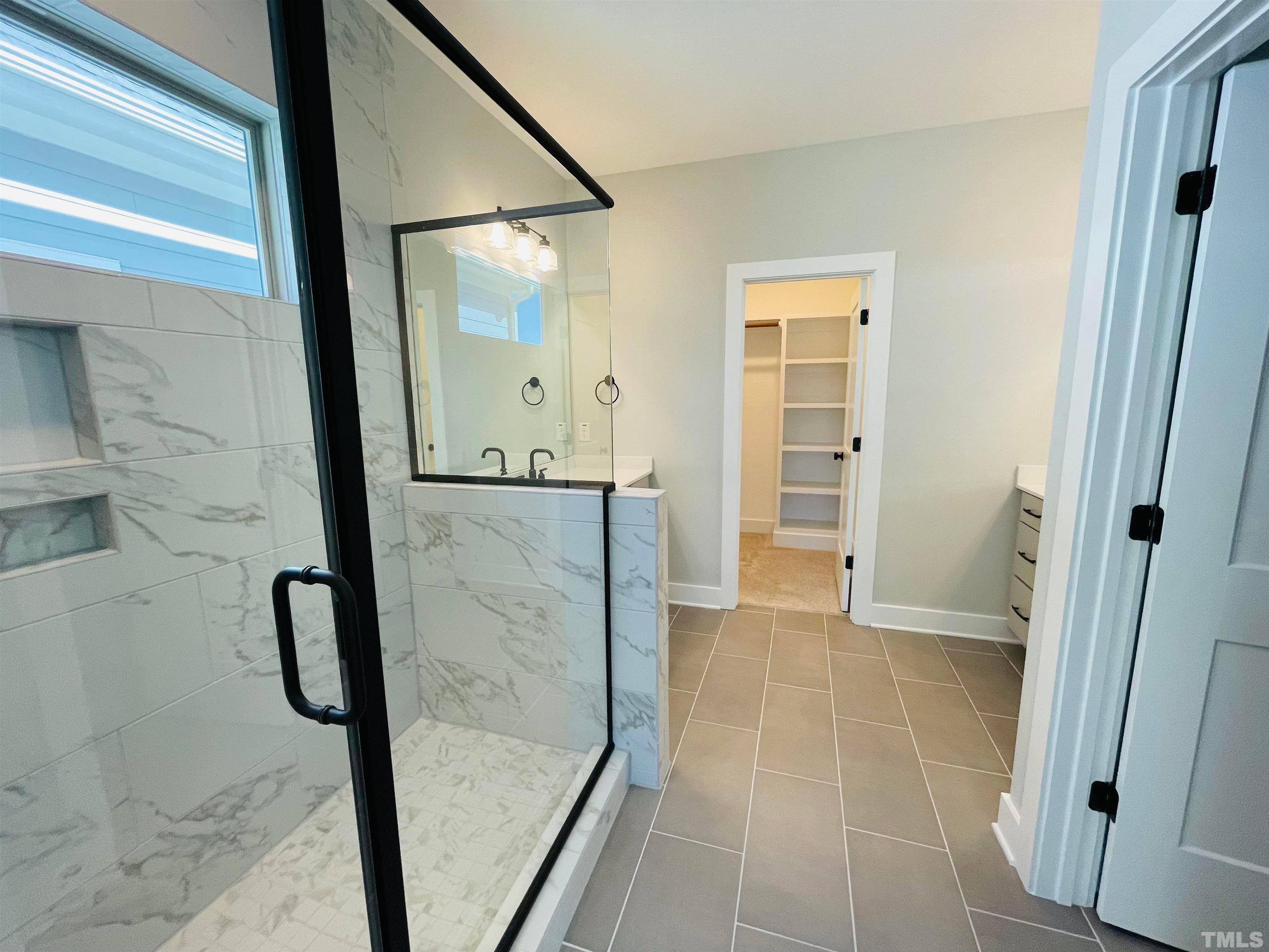 200 East Moore Street Apex, NC 27502 - Photo 15 of 32 a bathroom with a glass shower door