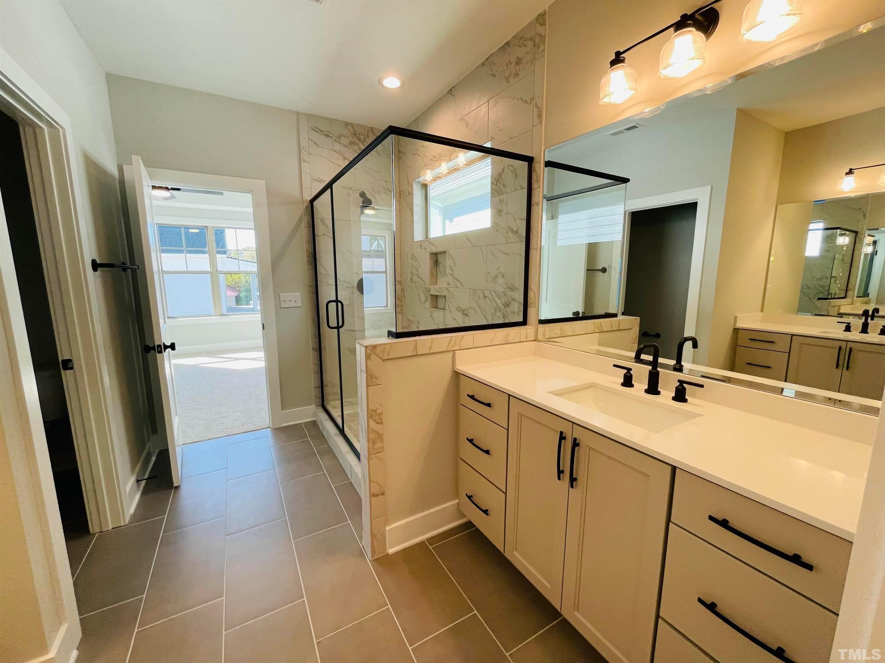200 East Moore Street Apex, NC 27502 - Photo 16 of 32 a spacious bathroom with a double vanity sink a mirror and a shower