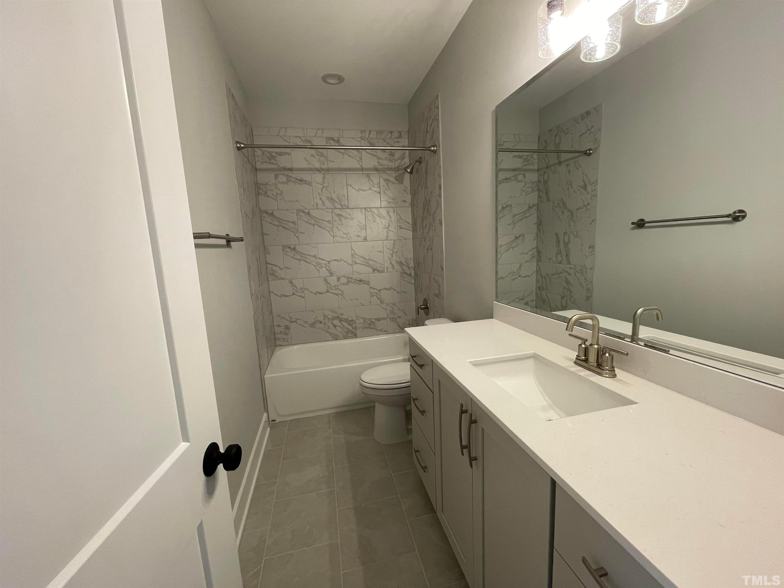 200 East Moore Street Apex, NC 27502 - Photo 27 of 32 a bathroom with a granite countertop sink toilet and shower