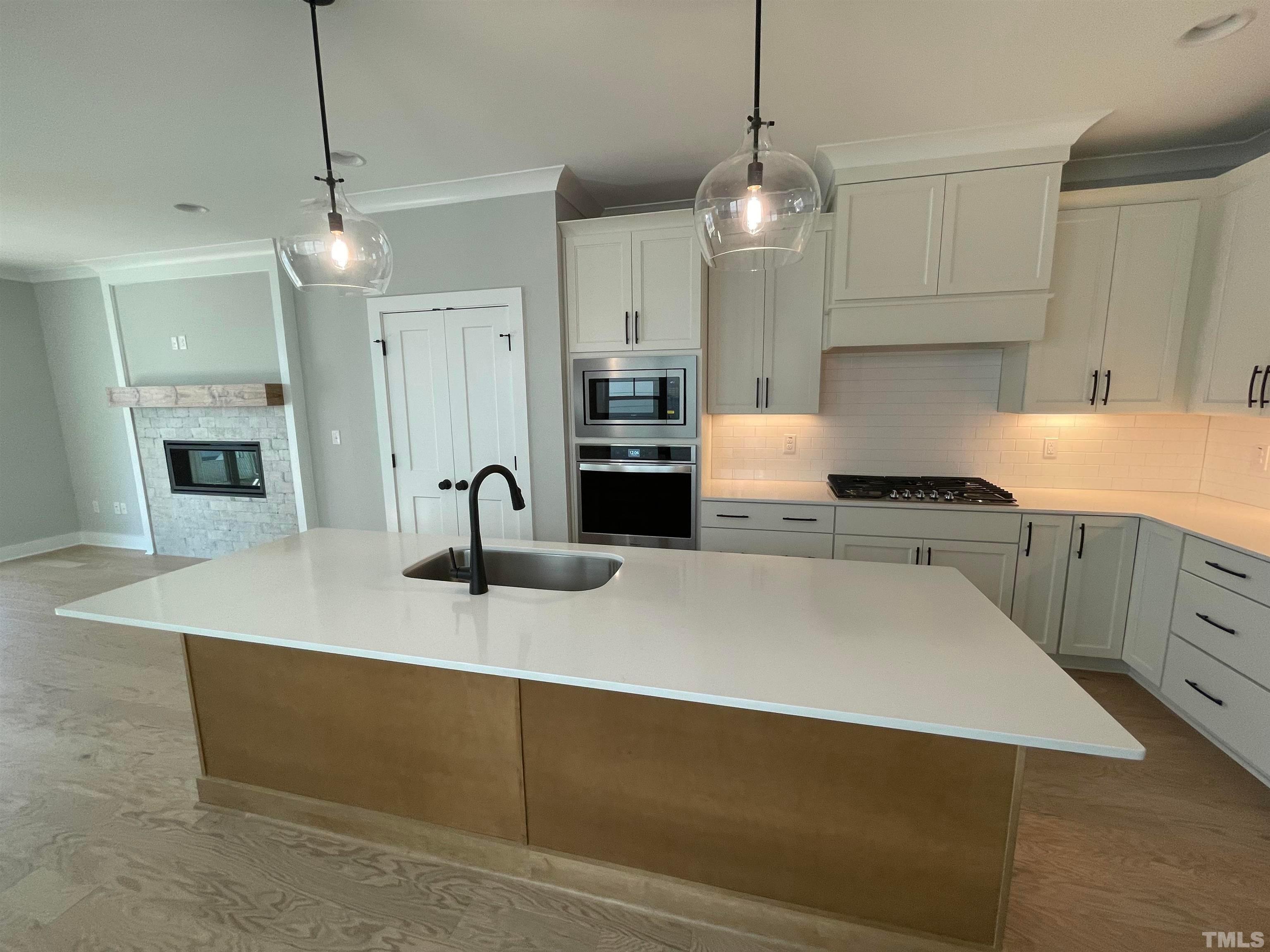 200 East Moore Street Apex, NC 27502 - Photo 5 of 32 a kitchen with stainless steel appliances granite countertop a sink a stove and a refrigerator
