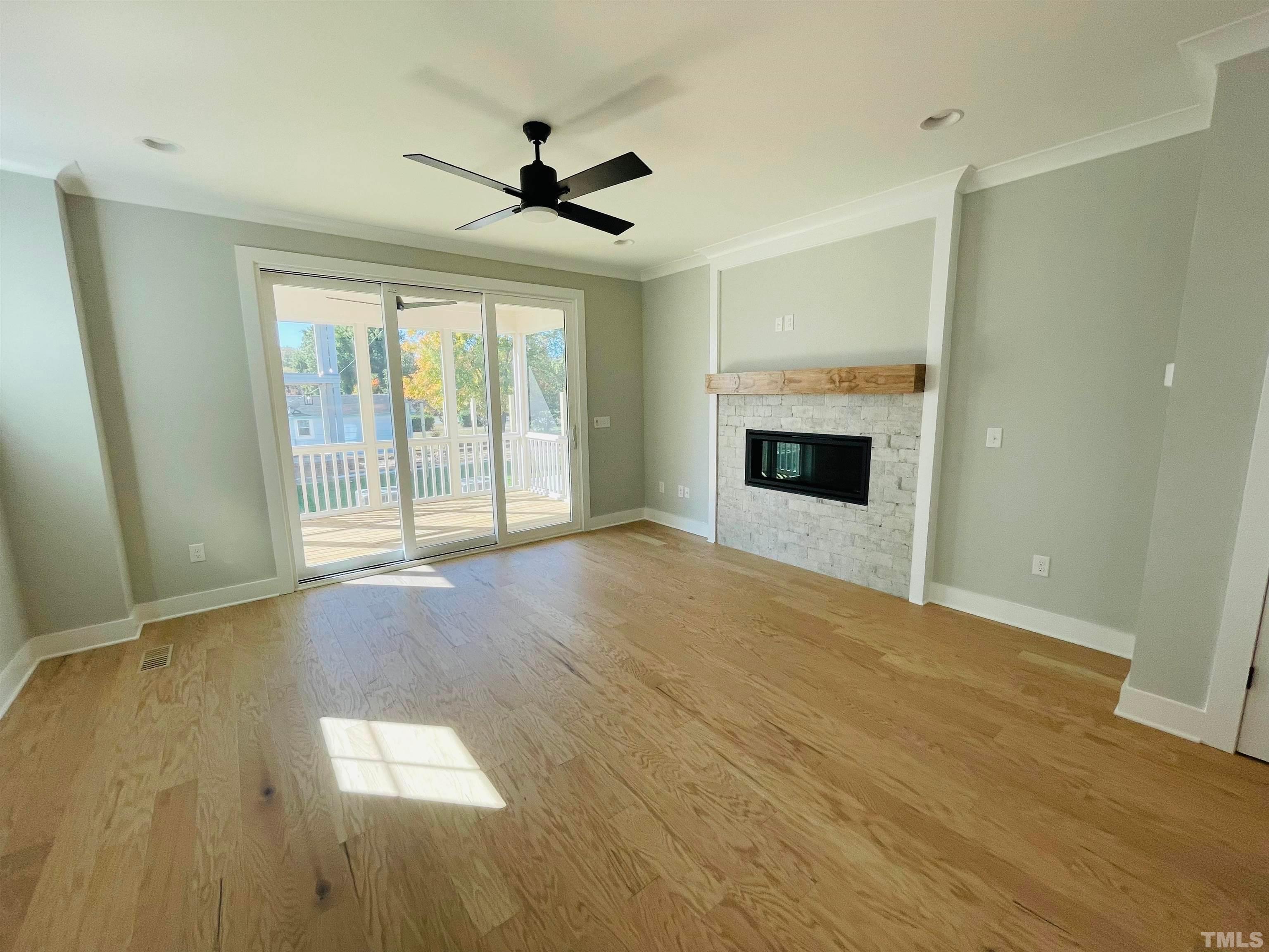 200 East Moore Street Apex, NC 27502 - Photo 9 of 32 a view of empty room with wooden floor and fireplace