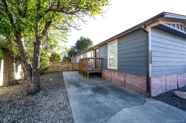 a view of a house with a backyard and trees