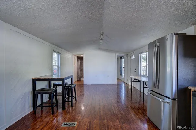 a view of a dining room with furniture a rug and wooden floor