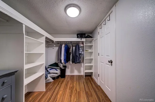 a view of walk in closet with clothes and shoes