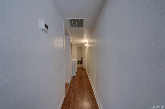 a view of a hallway with wooden floor