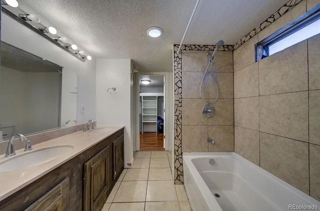 a bathroom with a bathtub double vanity sink and a shower