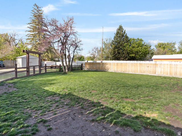 158 East 300 South Logan, UT 84321 - Photo 21 of 25 Fenced backyard featuring a storage shed