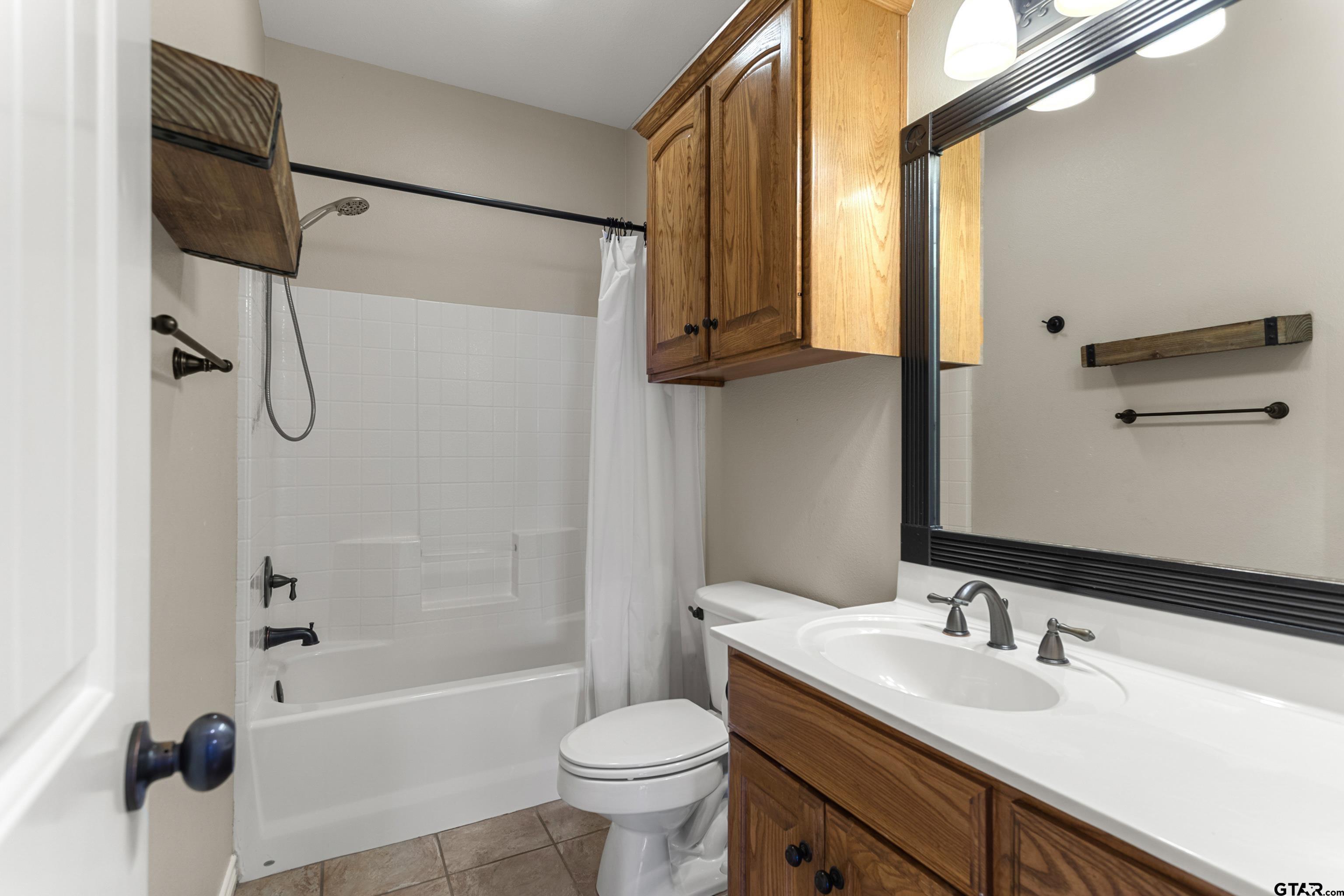 16551 Fox Run Lane Lindale, TX 75771 - Photo 24 of 41 a bathroom with a sink a toilet and a bathtub