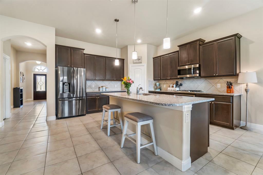 3610 Bastrop Street Melissa, TX 75454 - Photo 3 of 23 a kitchen with stainless steel appliances a refrigerator sink and microwave