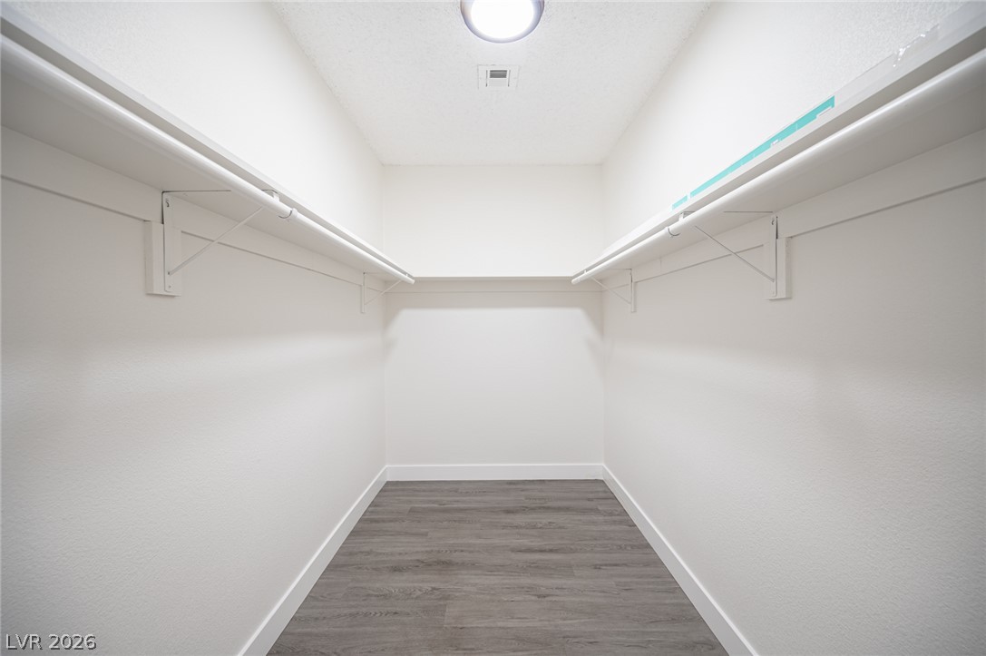 7041 North Decatur Boulevard Las Vegas, NV 89131 - Photo 20 of 33 Ample hanging space and shelving line this well-lit walk-in closet.