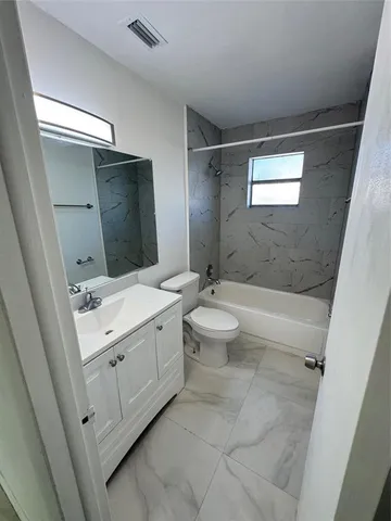 a bathroom with a double vanity sink toilet and mirror