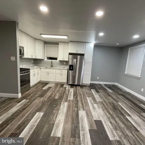 a view of a livingroom with a refrigerator a microwave and a sink