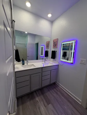 a bathroom with double vanity sink and mirror
