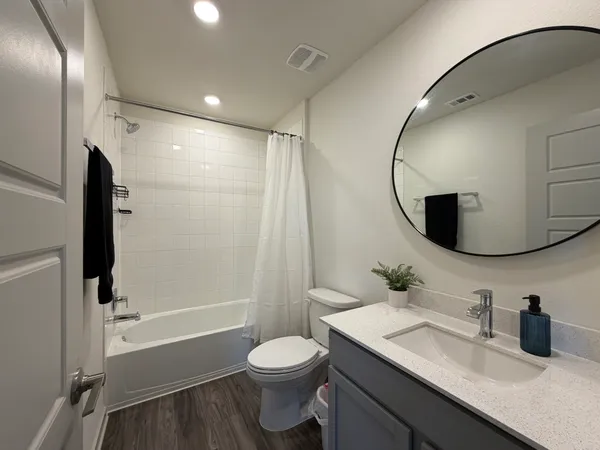 a bathroom with a granite countertop sink toilet and shower