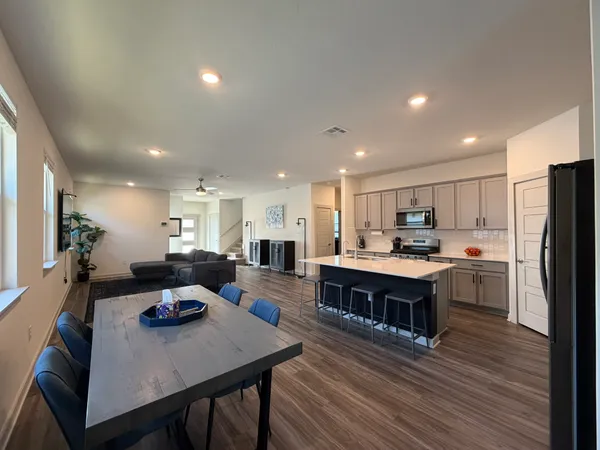 a living room with stainless steel appliances furniture stove and wooden floor
