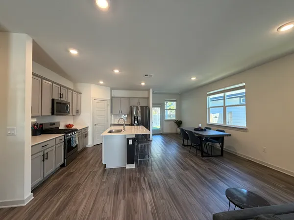 a kitchen with a sink and wooden floor