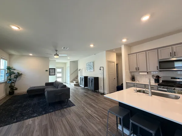 a kitchen with sink refrigerator dining table and chairs
