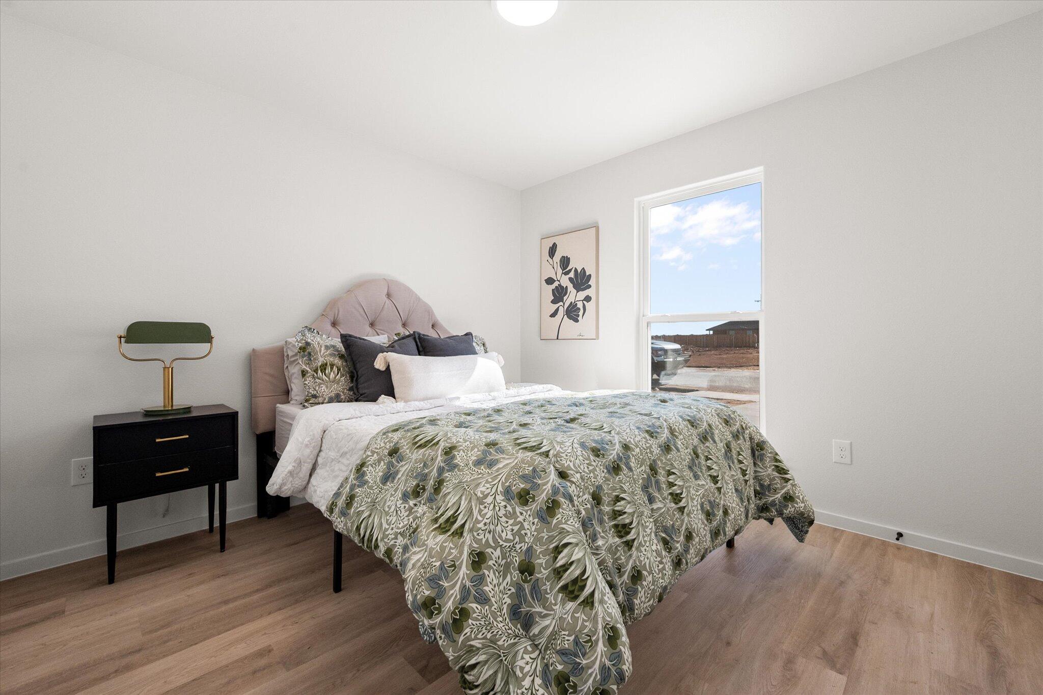 5506 Smith Street Lubbock, TX 79416 - Photo 11 of 16 a bedroom with a bed and a lamp on table