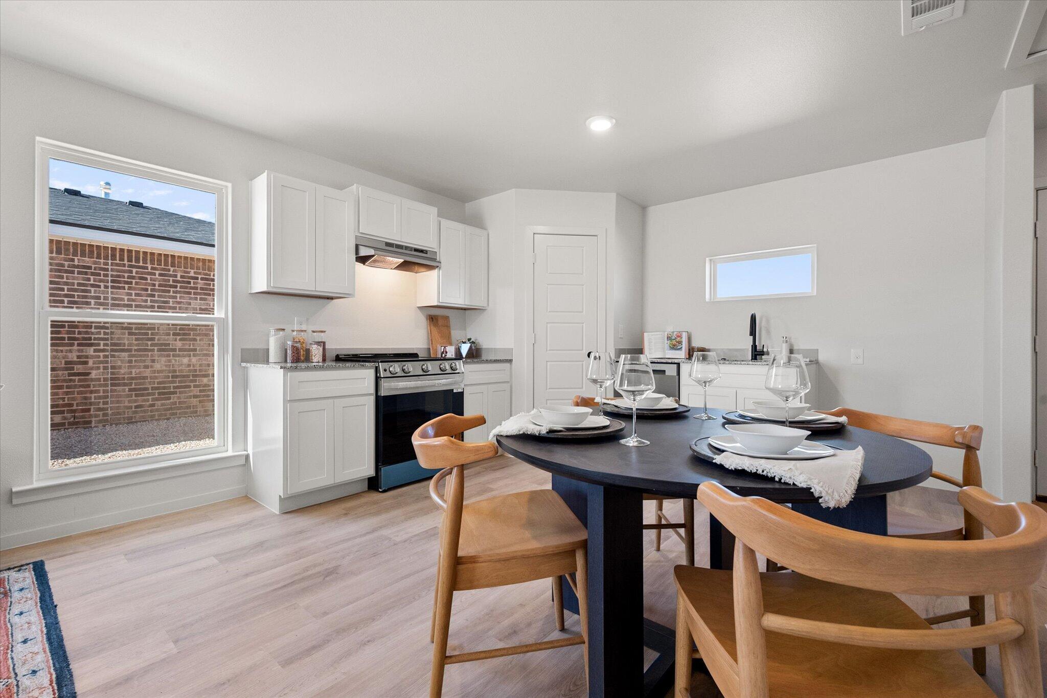 5506 Smith Street Lubbock, TX 79416 - Photo 8 of 16 a kitchen with a table chairs stove and cabinets