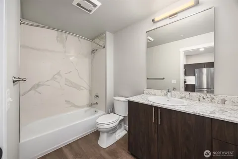 a bathroom with a sink toilet vanity and shower