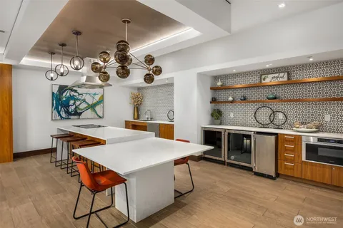 a kitchen with stainless steel appliances a stove a chimney a sink and cabinets