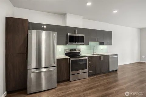 a kitchen with stainless steel appliances a refrigerator and a stove top oven