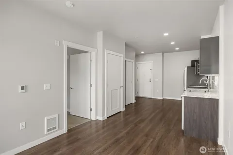 a view of a kitchen with wooden floor and a sink