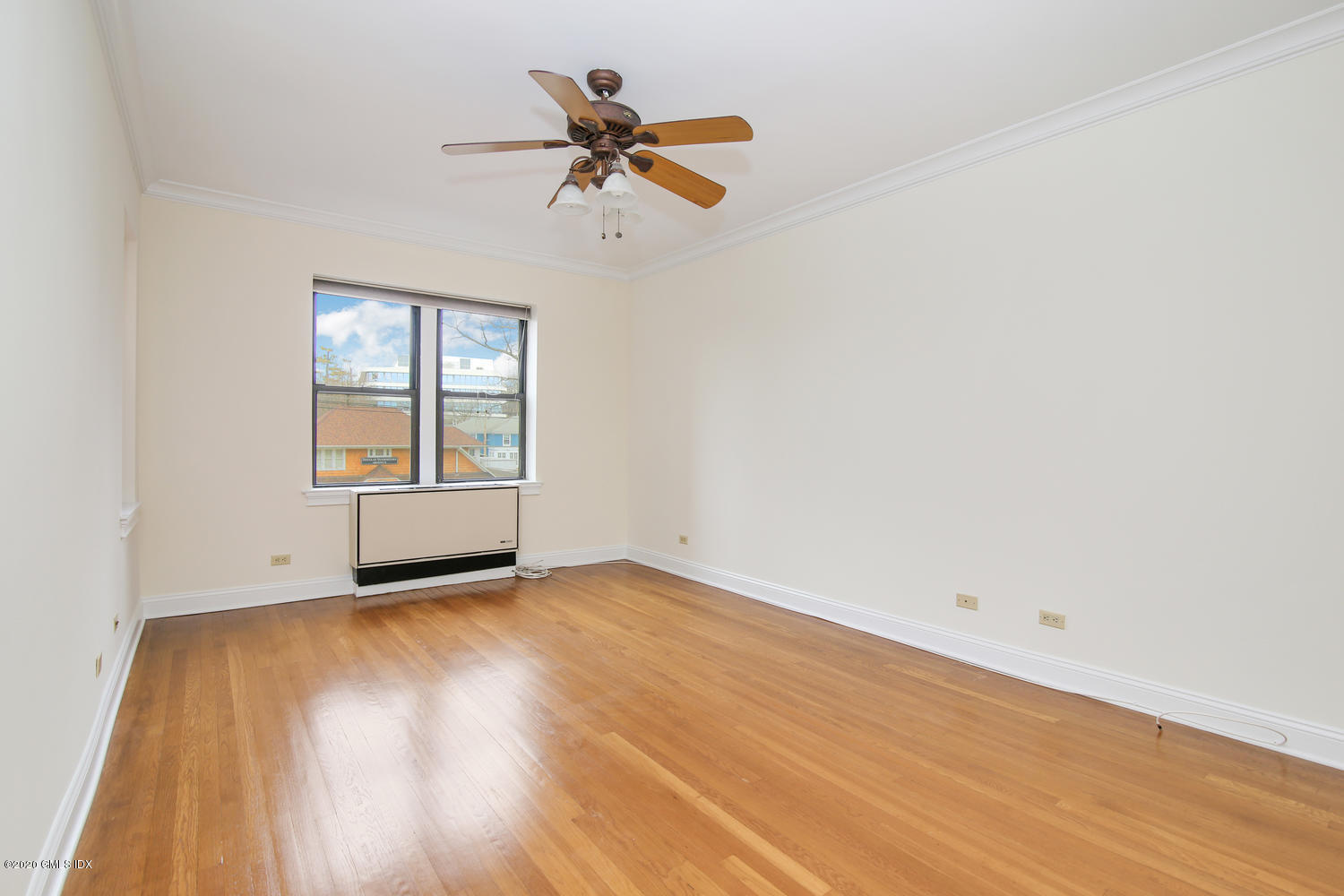 40 West Elm Street, Unit 3M Greenwich, CT 06830 - Photo 13 of 19 an empty room with wooden floor chandelier fan and windows