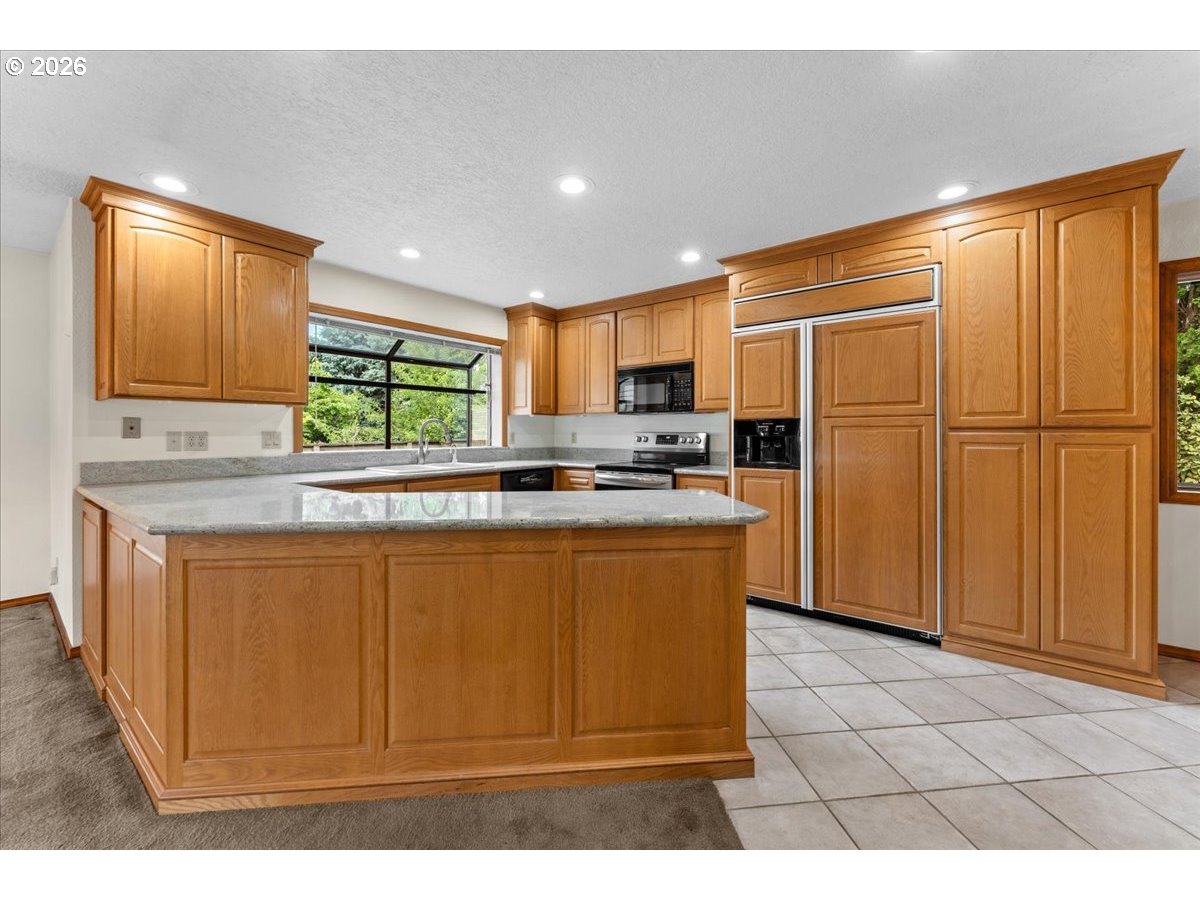 17501 Northeast Clackamas Street Portland, OR 97230 - Photo 4 of 38 a kitchen with stainless steel appliances granite countertop a refrigerator a sink a stove with wooden cabinets