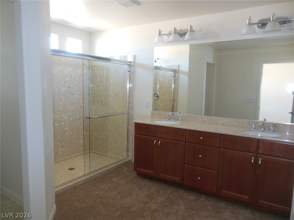 6390 Jackson Spring Road Las Vegas, NV 89118 - Photo 6 of 27 A well-appointed bath features a spacious shower and a vanity with dual sinks.