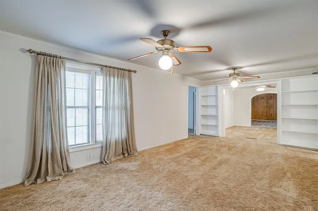a view of a livingroom with a ceiling fan and window