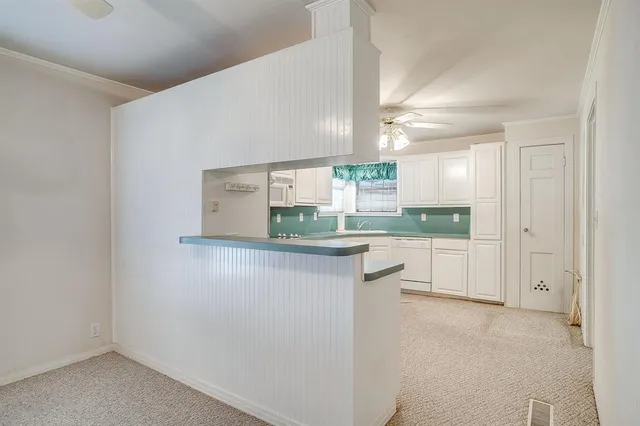 a kitchen with stainless steel appliances granite countertop white cabinets and window