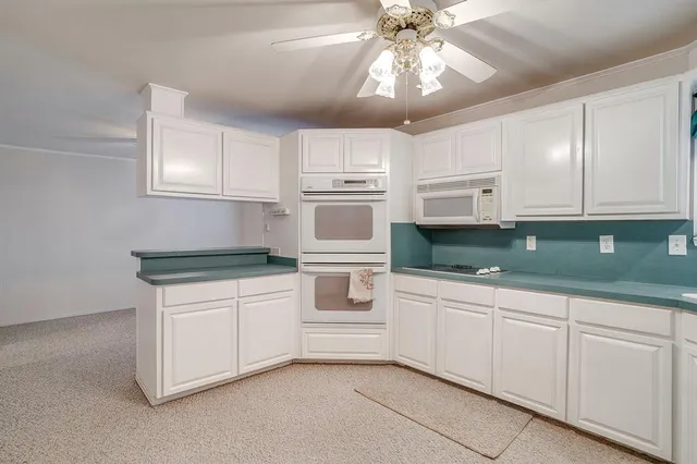 a kitchen with white cabinets and white appliances