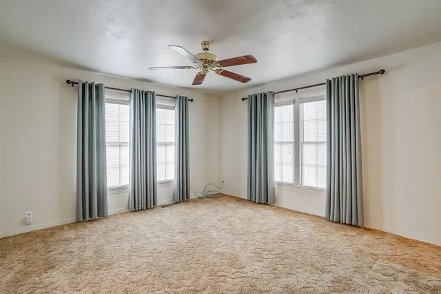 a view of empty room with ceiling fan