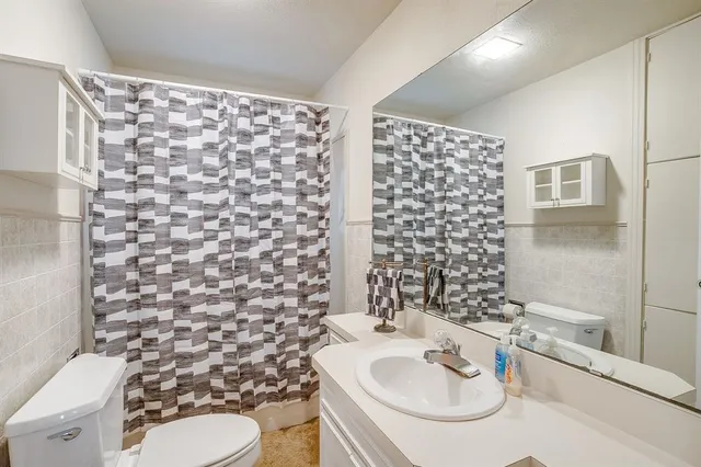 an empty room with chandelier fan and windows