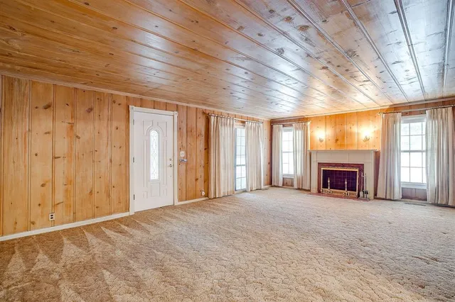 a view of an empty room with a fireplace and a window