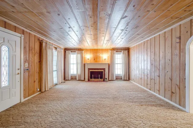 a view of an empty room with a fireplace and a window