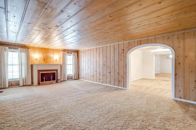 a view of an empty room with a fireplace and a window