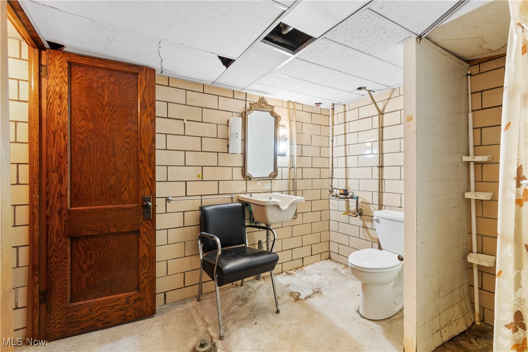 1527 Ridge Road Northwest Canton, OH 44703 - Photo 20 of 27 Bathroom featuring toilet, a paneled ceiling, concrete flooring, and sink