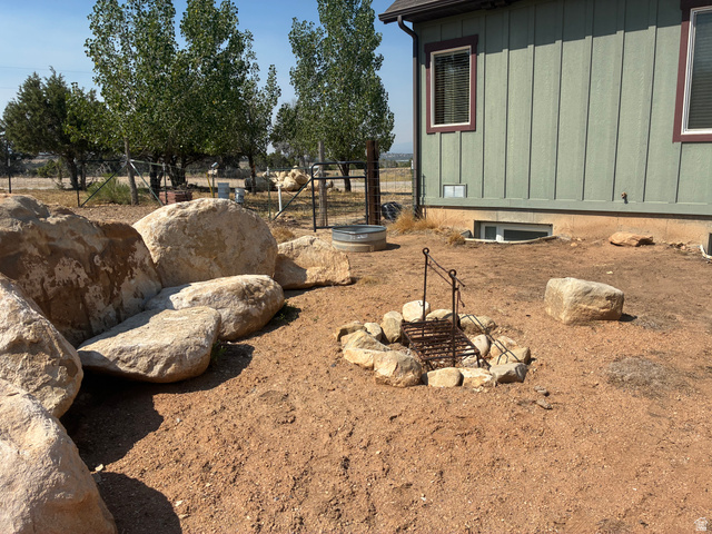 581 South 700 East Spring City, UT 84662 - Photo 27 of 42 Exterior featuring board and batten siding, rock-lined fire pit, and mature trees