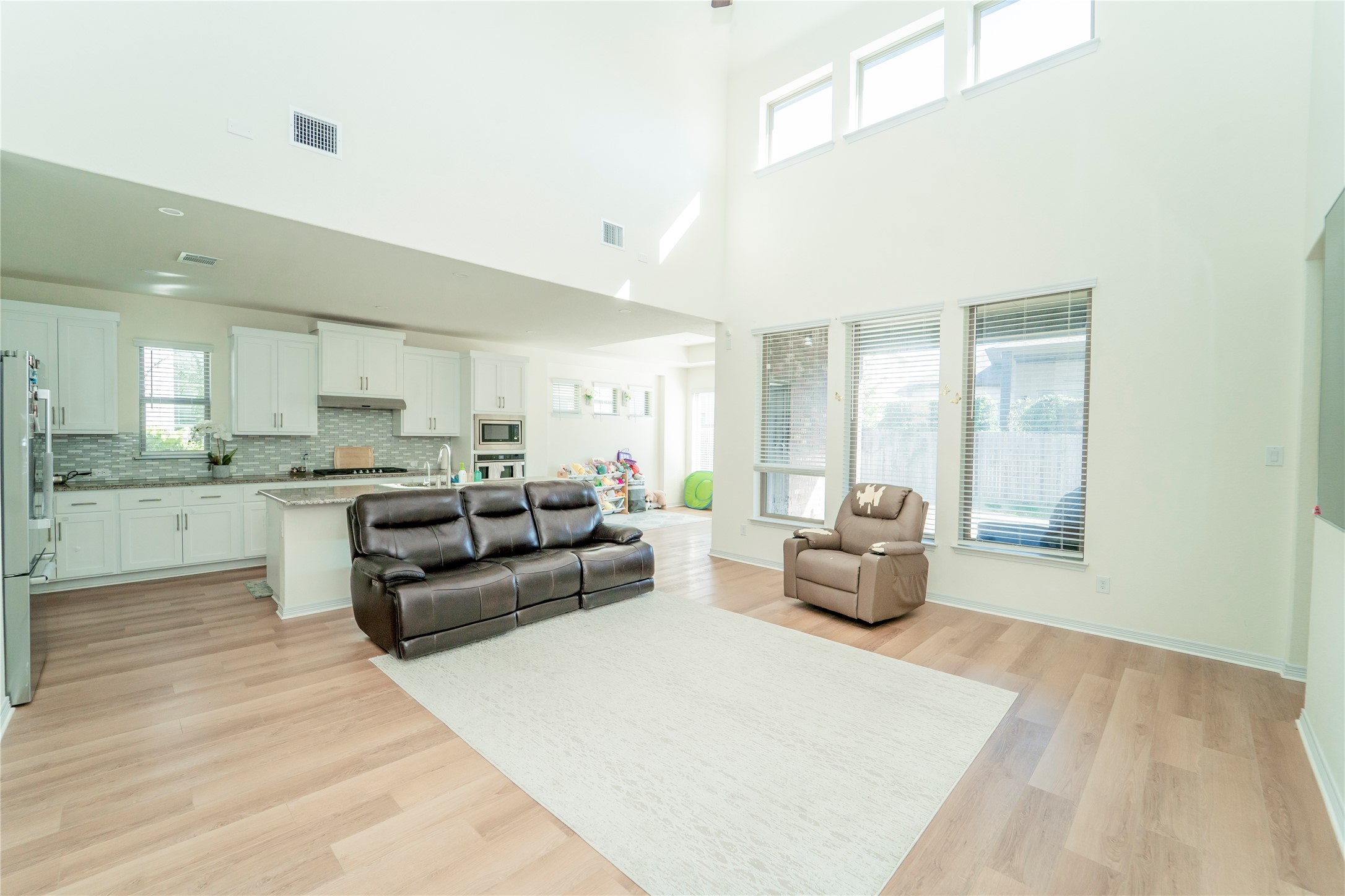 20813 Carries Ranch Road Pflugerville, TX 78660 - Photo 13 of 29 Living area featuring light wood-type flooring and a high ceiling