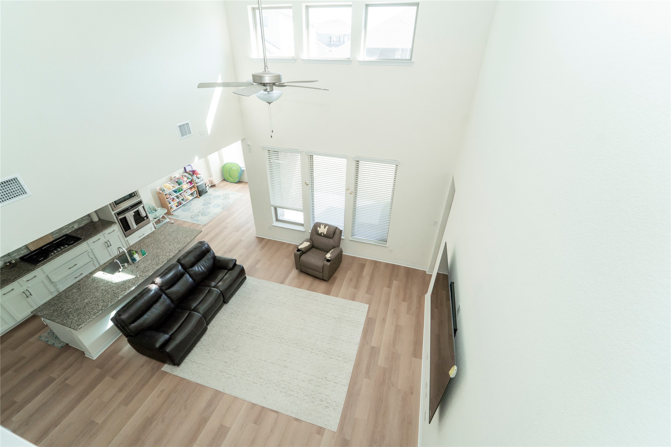 20813 Carries Ranch Road Pflugerville, TX 78660 - Photo 14 of 29 Living room with light wood-style floors, a high ceiling, plenty of natural light, and a ceiling fan